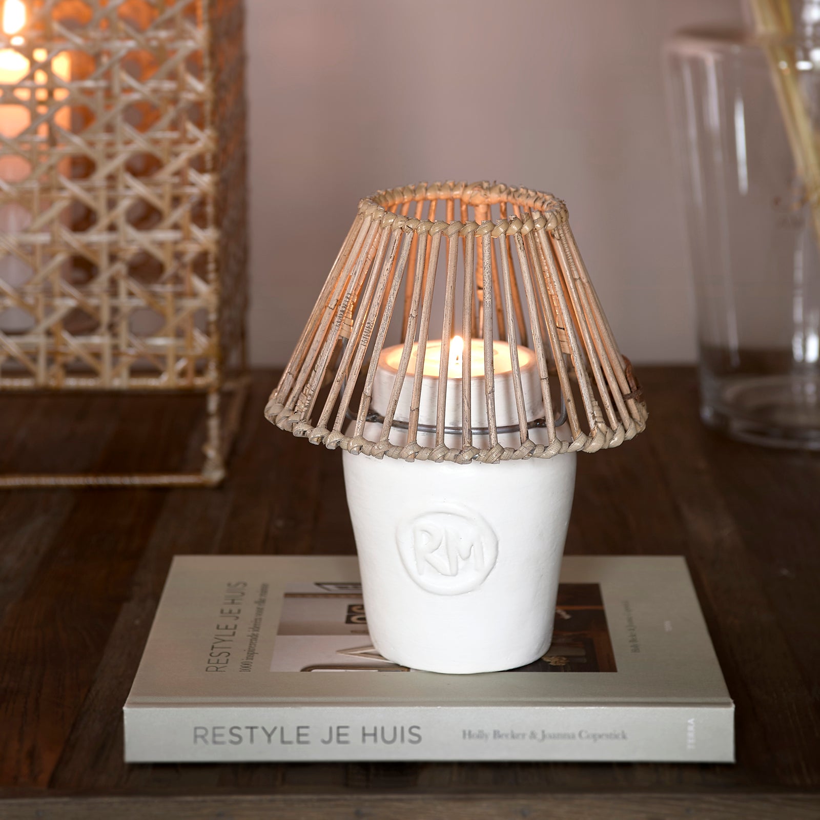 CANDLE HOLDER with a rattan roof by Riviera Maison on a book