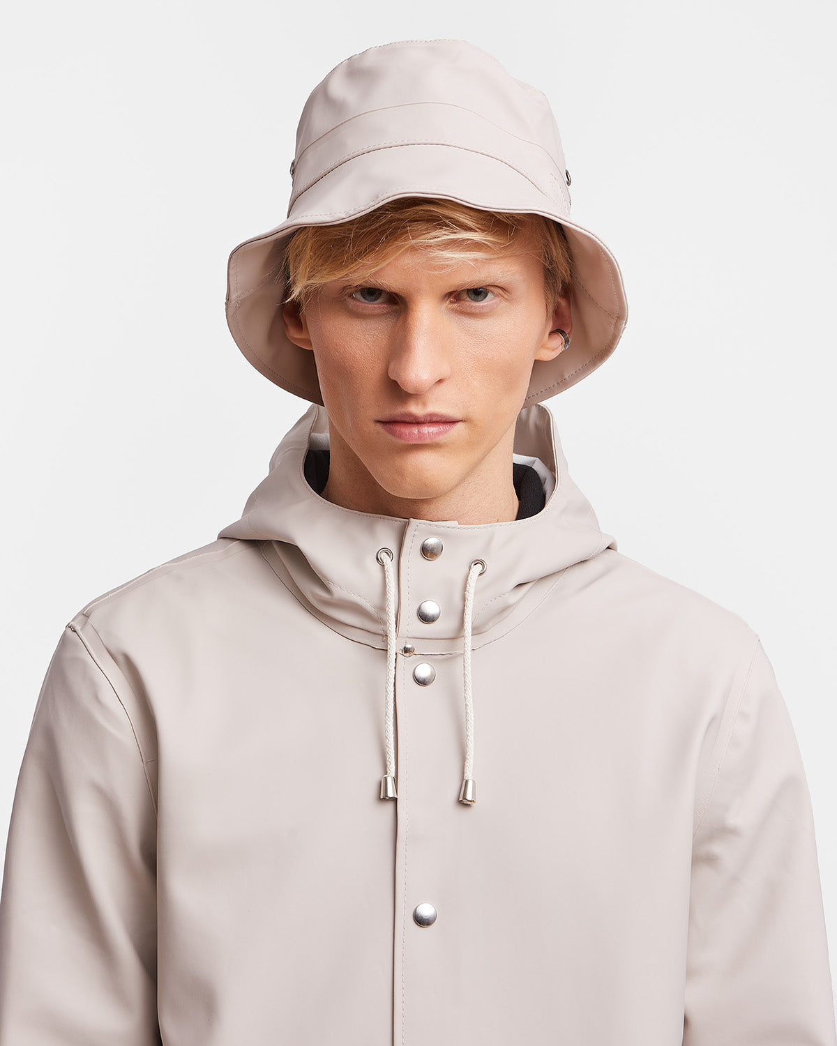 A man with a Bucket Hat in color light sand by Stutterheim