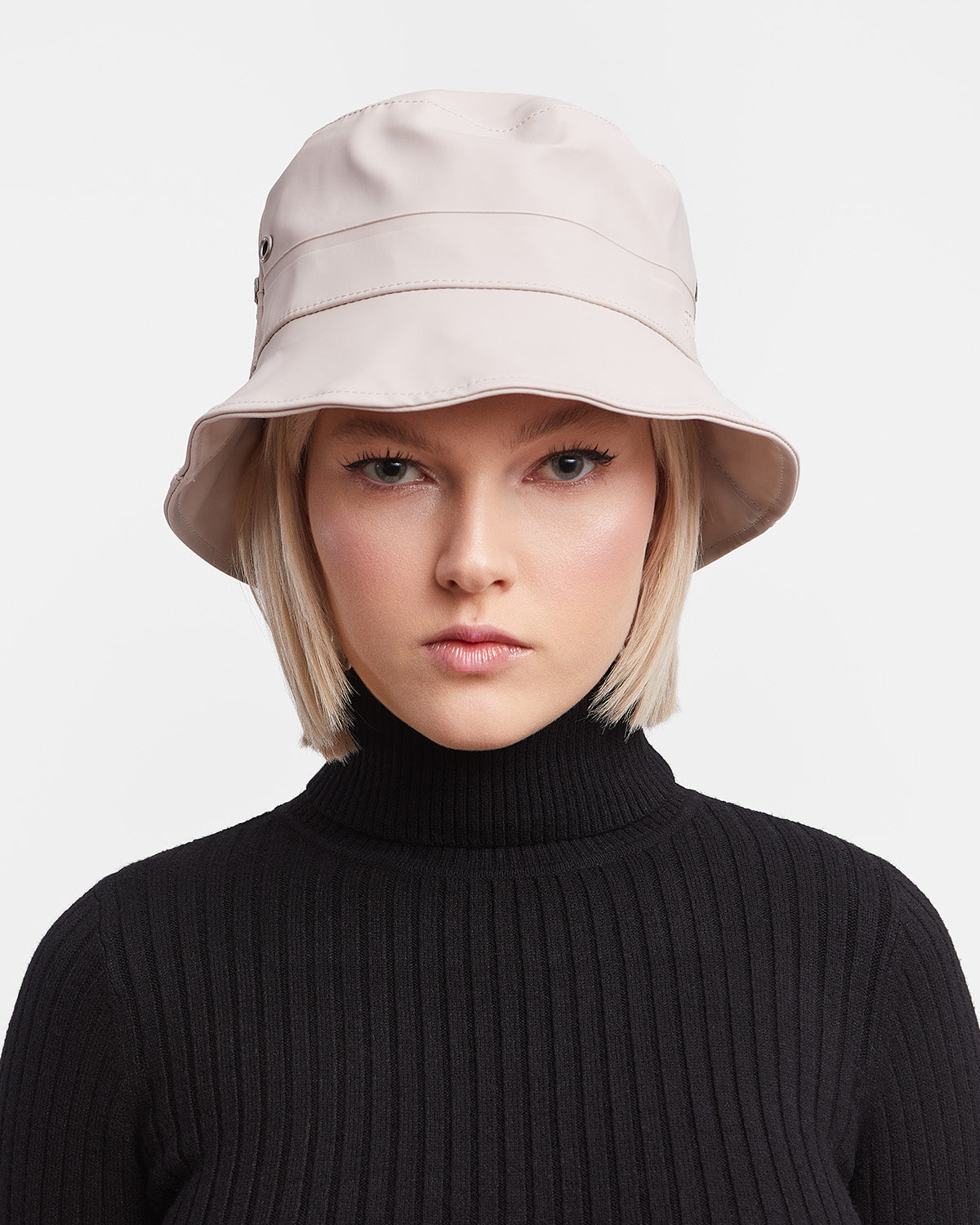 A woman with a Bucket Hat in color light sand by Stutterheim