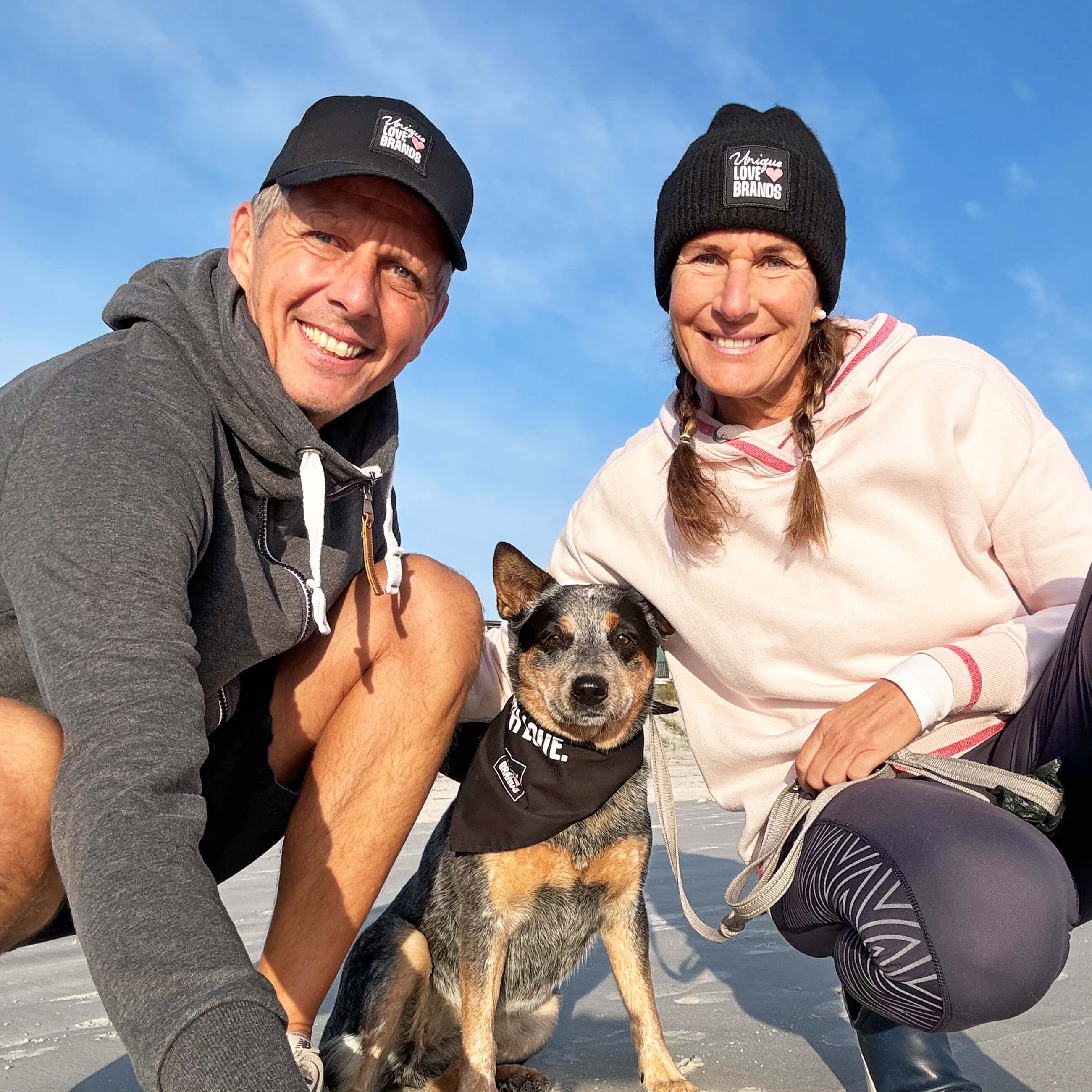 A woman and a man with their dog at the beach
