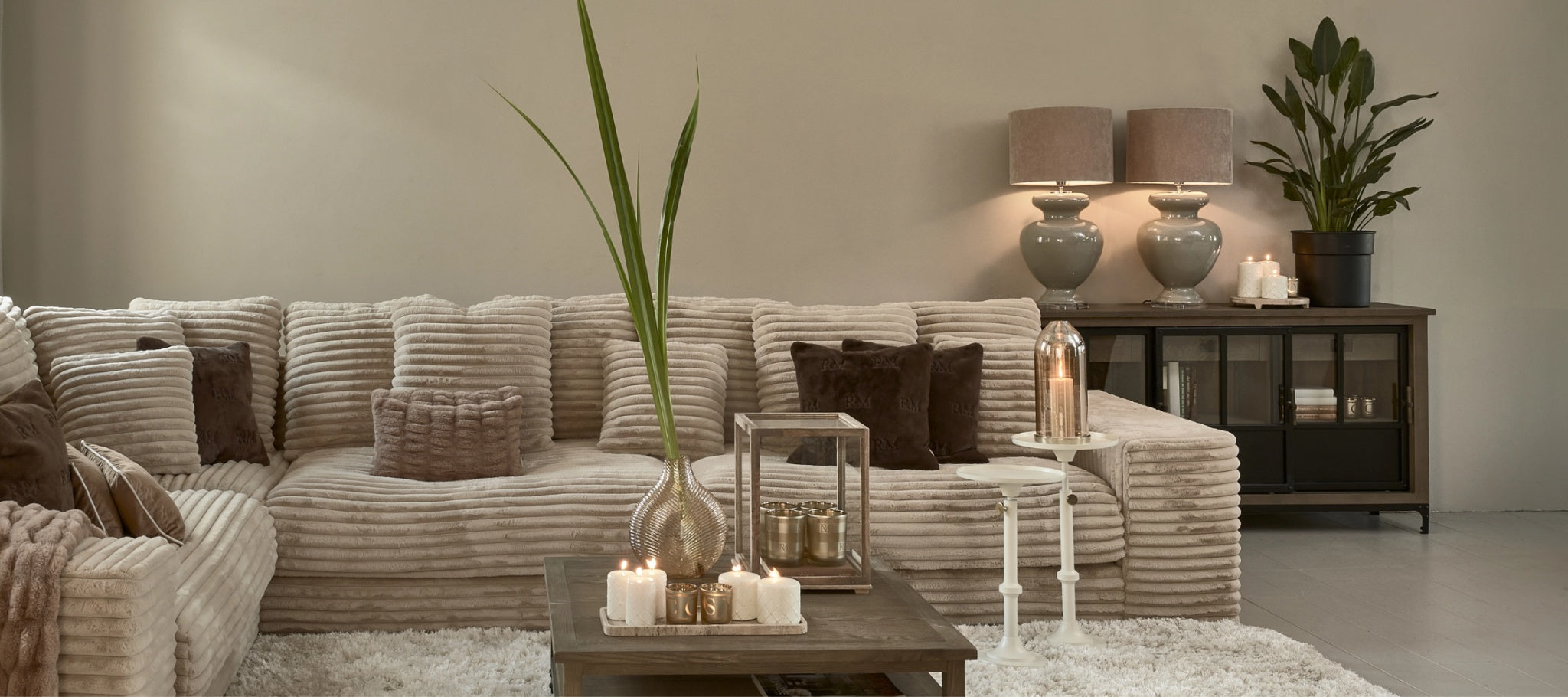 Riviera Maison Living room with sofa in color beige, table candle and decoration