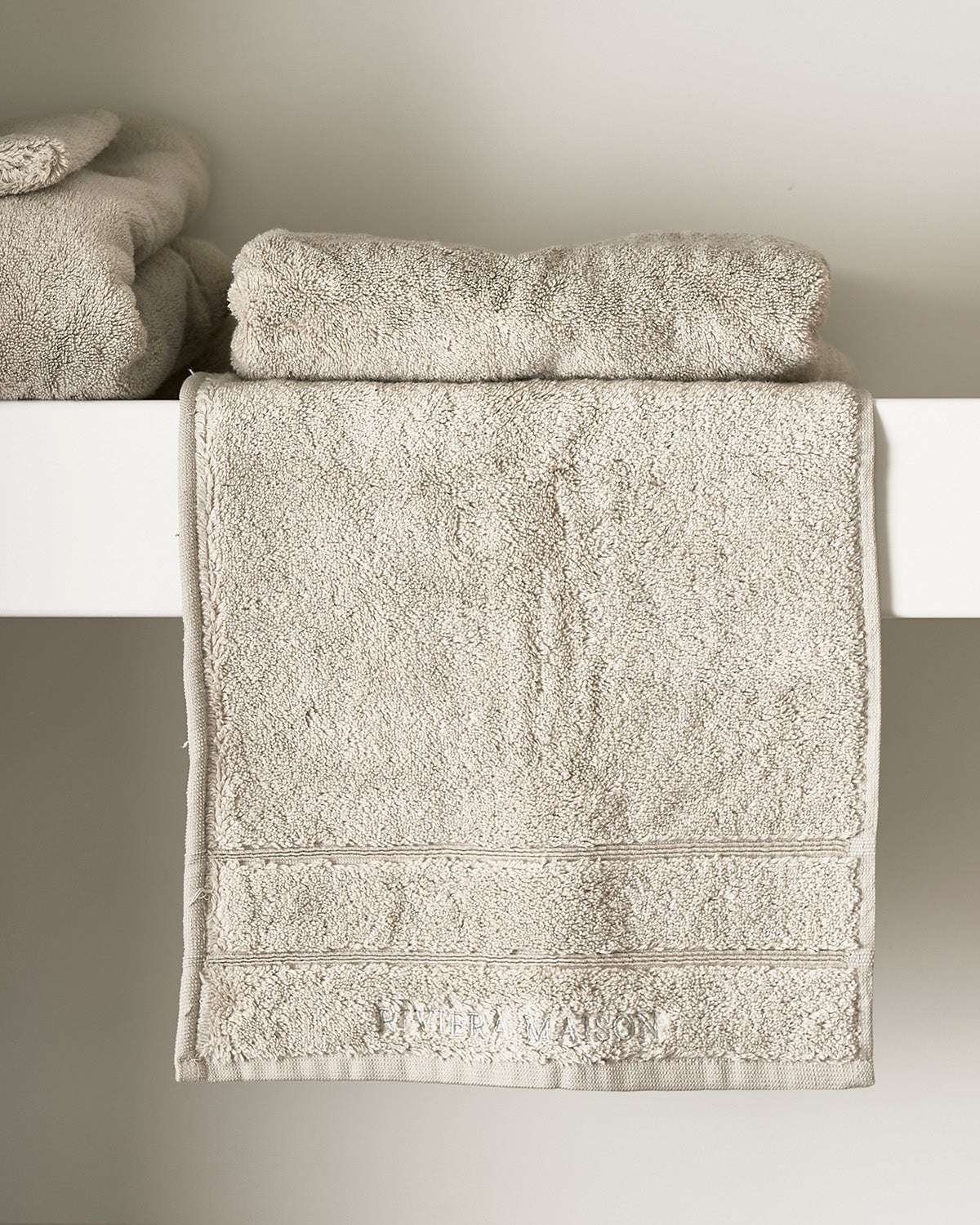 TOWELS  soft, thick, stone-colored  on a chair by Riviera Maison