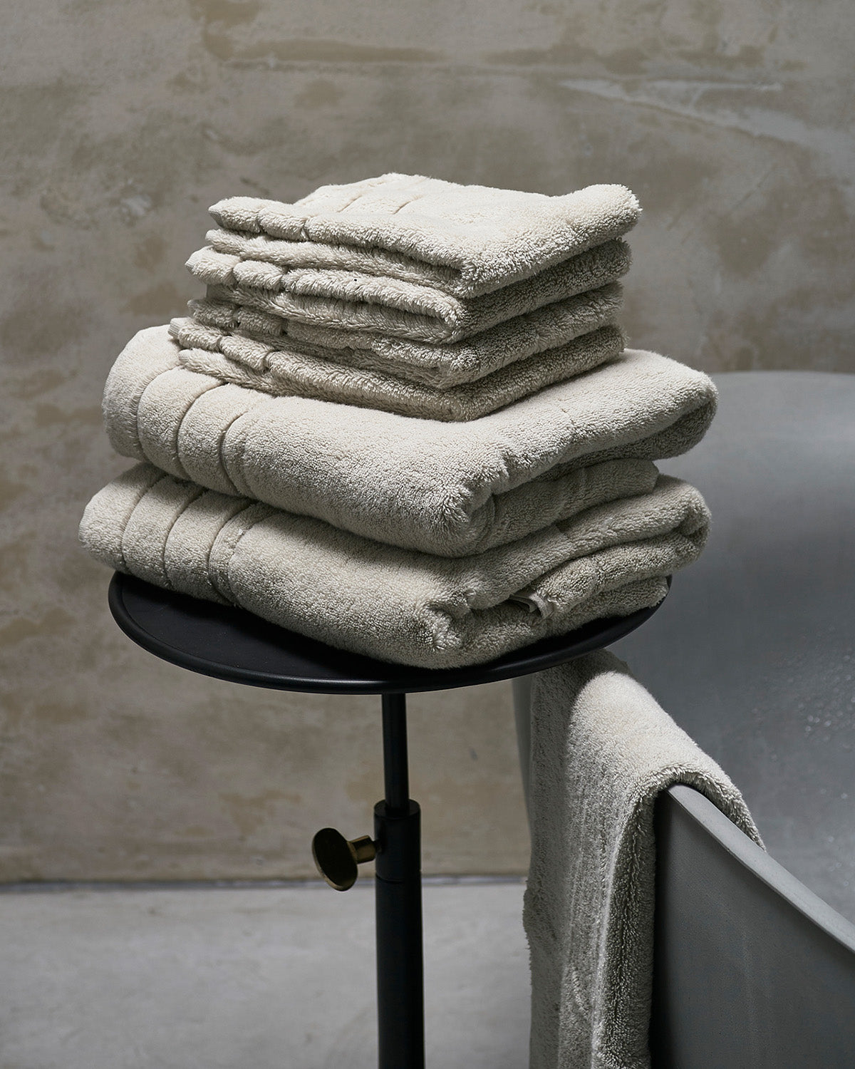 TOWELS  soft, thick, stone-colored  on a chair by Riviera Maison