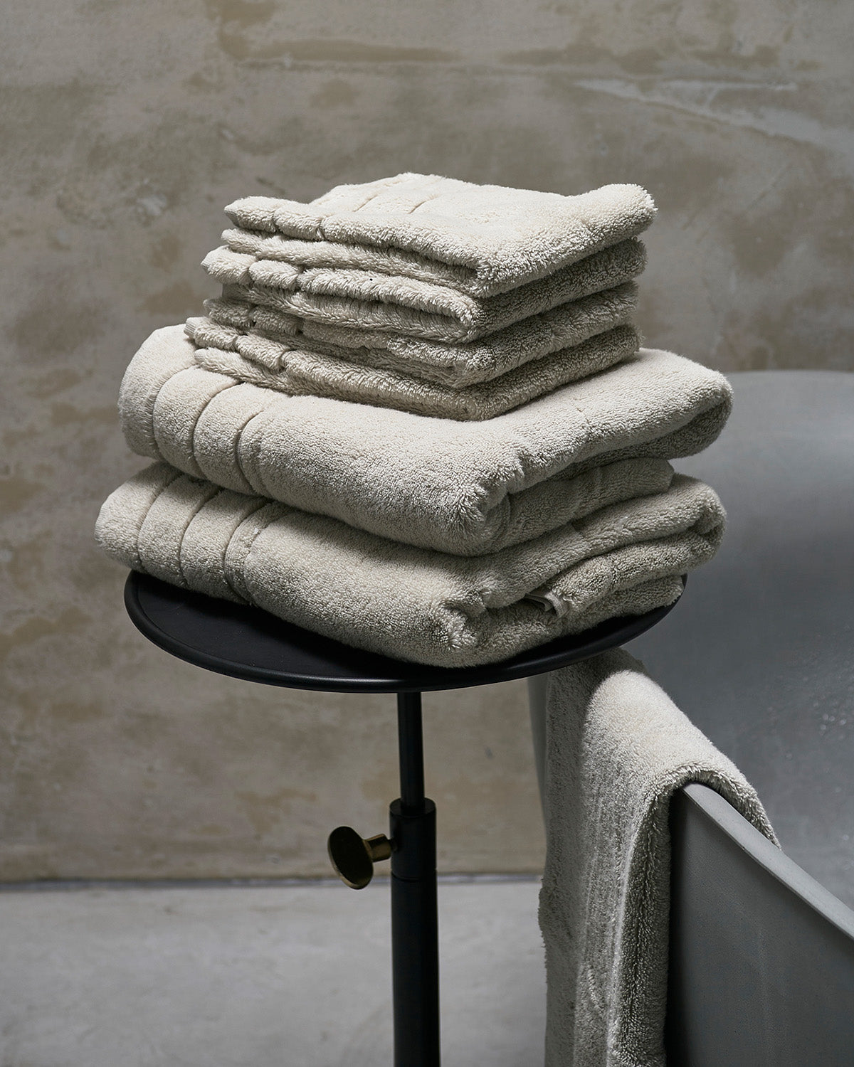TOWELS  soft, thick, stone-colored  on a chair by Riviera Maison