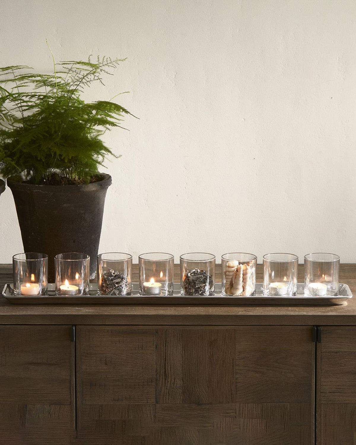 TRAY SILVER, eight tea light glasses on a shiny aluminum tray, on a wooden sideboard