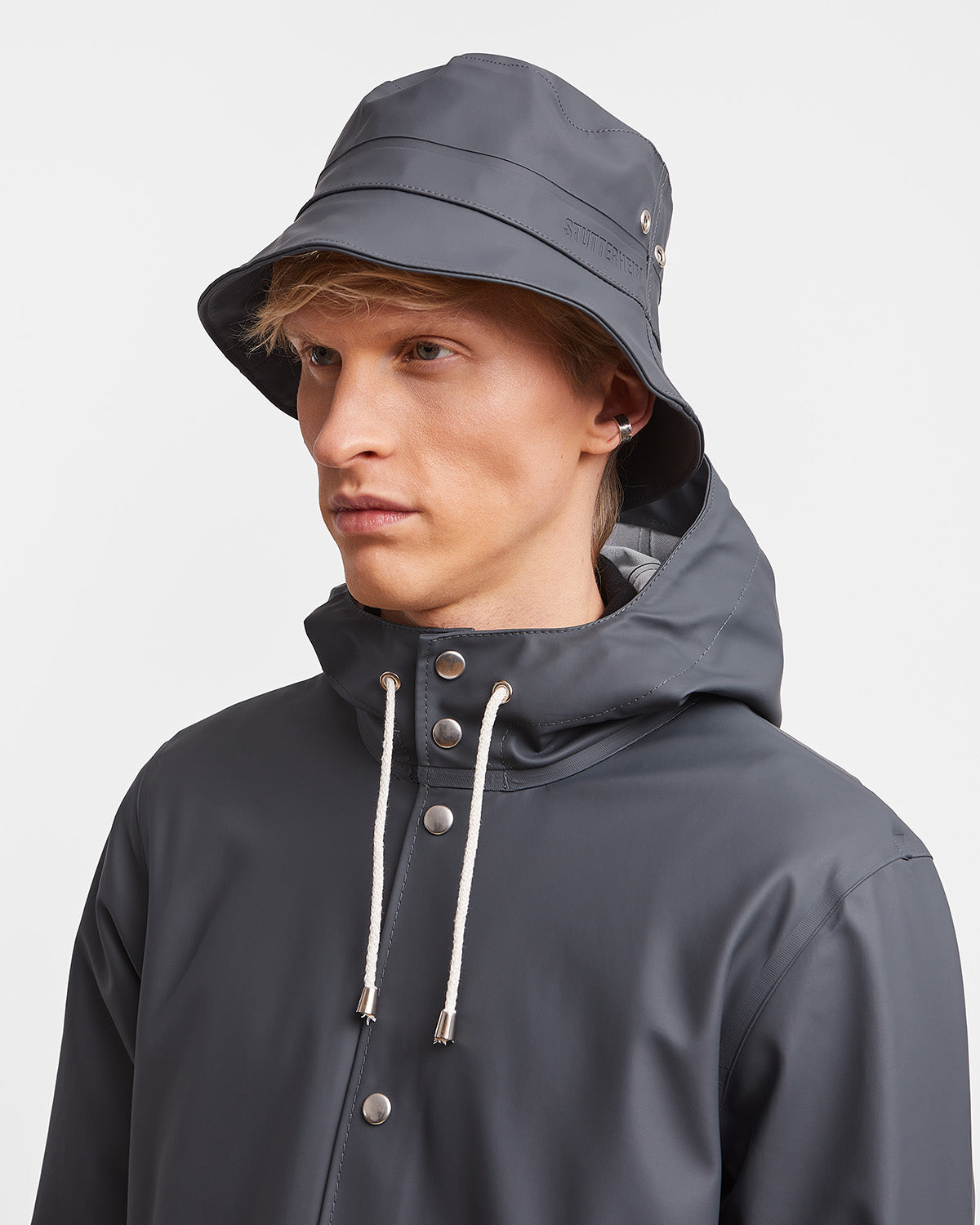A man with Bucket Hat in color charcoal by Stutterheim seen from behind