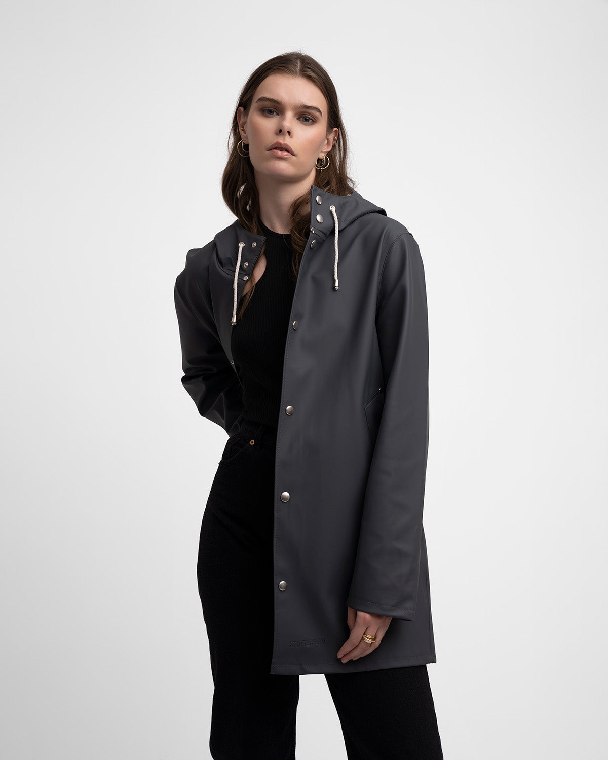 A woman with a Raincoat in color charcoal by Stutterheim